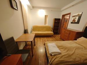 a small room with two beds and a table at Vistula Home in Płock