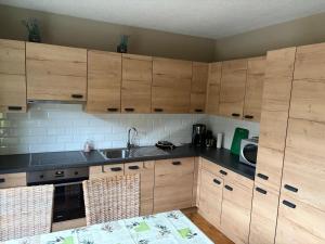 a kitchen with wooden cabinets and a sink at Balcons de la semois in Vresse-sur-Semois +14 photos
