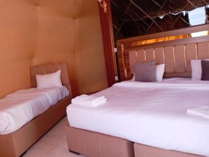 two beds sitting next to each other in a room at Star Gate Camp in Wadi Rum +6 photos