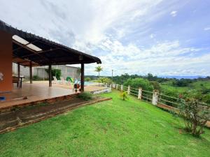 a house with a wooden deck and a fence at Chacara Vale do Barreiro in Taubaté