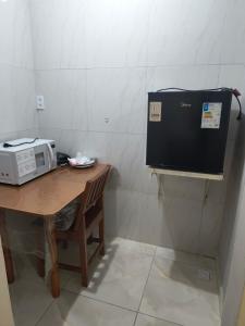 a microwave sitting on top of a wooden table at Flat Padim Ciço in Piranhas +4 photos