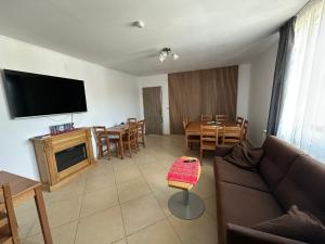 a living room with a couch and a tv and a table at Cassa-Grande in Bozovici