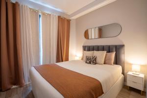a bedroom with a bed and a mirror on the wall at Golden Tide in Machico
