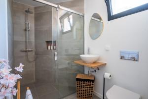 a bathroom with a shower with a sink and a mirror at Golden Tide in Machico +6 photos