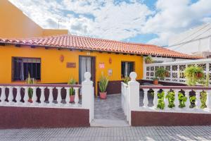 a yellow house with a white fence at Casa Petra - Traditional Canary House in Güimar