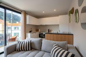 a living room with a couch and a kitchen at Golden Tide in Machico
