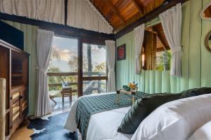 a bedroom with a bed and a large window at Pousada Parador 33 in Biguaçu
