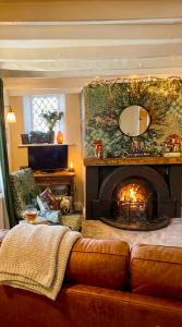 a living room with a couch and a fireplace at Thatched Cottage on Northumberland border in Kirk Yetholm +62 photos