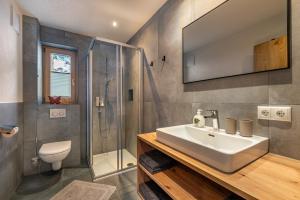 a bathroom with a sink and a shower and a toilet at Ferienhaus Leo in See +45 photos