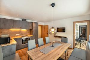 a kitchen and dining room with a wooden table and chairs at Ferienhaus Leo in See