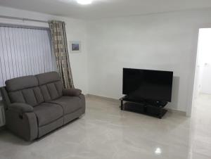 a living room with a couch and a flat screen tv at the foyle bridge apartment in Derry Londonderry