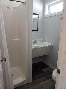 a white bathroom with a sink and a toilet at Motel Domaine Expédition in Labelle