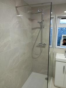 a shower with a glass door in a bathroom at the foyle bridge apartment in Derry Londonderry +39 photos