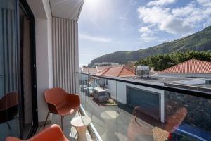 a balcony with a view of a car parked on the street at Golden Tide in Machico
