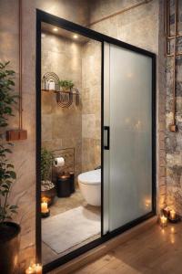 a bathroom with a toilet and a glass door at FİNTOZ BUTİKA New in Karaburun +104 photos