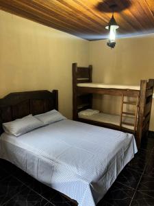 a bedroom with a bed and two bunk beds at Chalé aconchegante em Resende in Resende