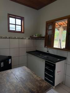 a kitchen with a sink and a window at Chalé aconchegante em Resende in Resende