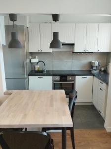 a kitchen with a wooden table with chairs in it at Na Sadowej in Grodzisk Mazowiecki