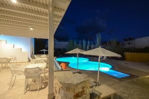 
an outdoor pool with umbrellas and chairs at Hotel Francesca in Agios Prokopios
