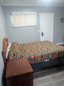a bedroom with a bed and a table and a window at Southland Motor Lodge Hotel in Woodhaven