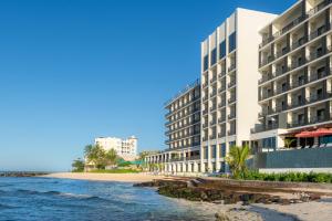 a hotel on the beach next to the ocean at Hotel Indigo Bridgetown Barbados by IHG in Bridgetown