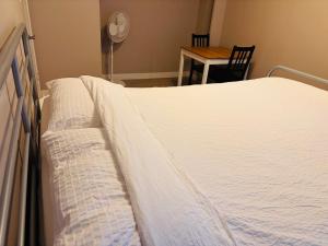 a bed in a room with a table and a chair at 6th Floor 2-Bedroom Condo with Parking in Calgary