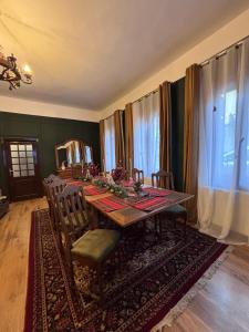 a dining room with a long table and chairs at Conacul Fluturilor in Sinaia