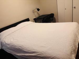 a bedroom with a white bed and a chair at Cozy 2-Bedroom Condo with Parking in Calgary