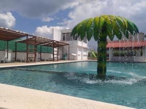 a palm tree in the middle of a swimming pool at Hotel & Cabañas Malinche in Huamantla