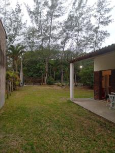 a backyard of a house with a grass yard at Sol & mar Hospedagem - Boqueirão Sul Via Balsa Cananéia in Ilha Comprida