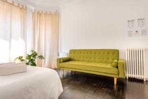 a green couch in a room with a bed at HT MIRIBILLA habitaciones turísticas sin ascensor in Bilbao