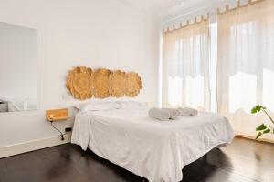 a white bedroom with a bed with two towels on it at HT MIRIBILLA habitaciones turísticas sin ascensor in Bilbao