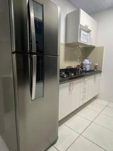 a stainless steel refrigerator in a kitchen with white cabinets at Apartamento com 3 quartos in Boa Vista