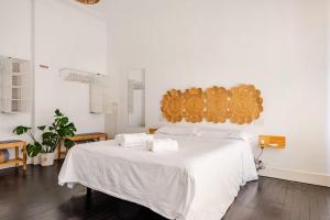a bedroom with a white bed with towels on it at HT MIRIBILLA habitaciones turísticas sin ascensor in Bilbao