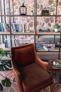 a brown chair in a room with a book shelf at Hotel Shoshana - Adults Only in Eilat
