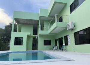 a house with a swimming pool in front of it at MeMe's Place in Placencia