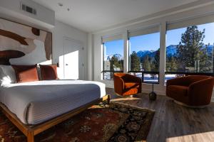a bedroom with a bed and two chairs and windows at The Sierra House in Mammoth Lakes +67 photos