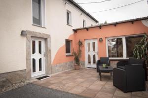 a patio in front of a house with a couch at Schusters Lindenhof in Bautzen