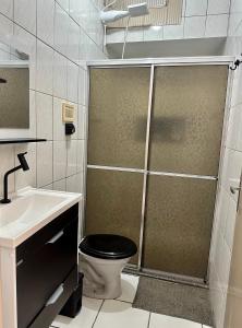 a bathroom with a shower with a toilet and a sink at Apartamento Central in Passos +22 photos