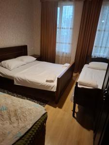 a bedroom with two beds and two windows at Food Delivery Taxi AI Powered Support in Martvili
