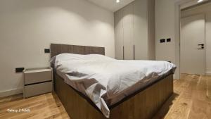 a bedroom with a large bed with white sheets at Zemun Golax Apartments in Belgrade +38 photos