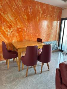 a dining room with a wooden table and chairs at Résidence NDAR in Saint-Louis
