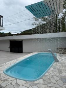 a swimming pool with a fountain in a yard at Sobrado 3 Praias in Ubatuba