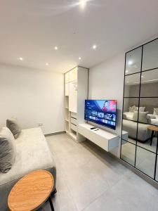 a living room with a bed and a television at MAISON 9 Apartments Surulere in Lagos
