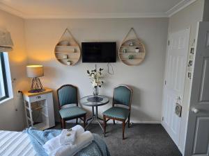 a bedroom with a bed and a table and chairs at Island View in Tauranga
