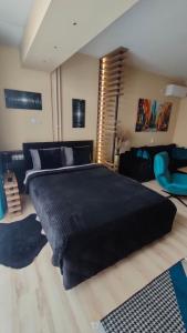 ein Schlafzimmer mit einem großen schwarzen Bett und einer Couch in der Unterkunft Stan na dan Premium 030 in Bor