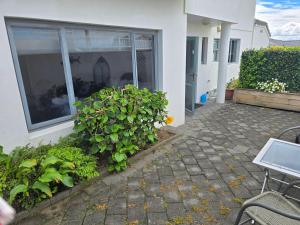 a patio of a house with a window and plants at Island View in Tauranga