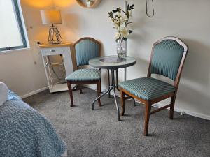 a room with two chairs and a table and a table and chairs at Island View in Tauranga