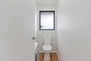 a bathroom with a toilet and a window at Suthar's Home in Wellington