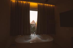 a bathroom with a bath tub with a window at Pharaohs Land Hotel in Cairo